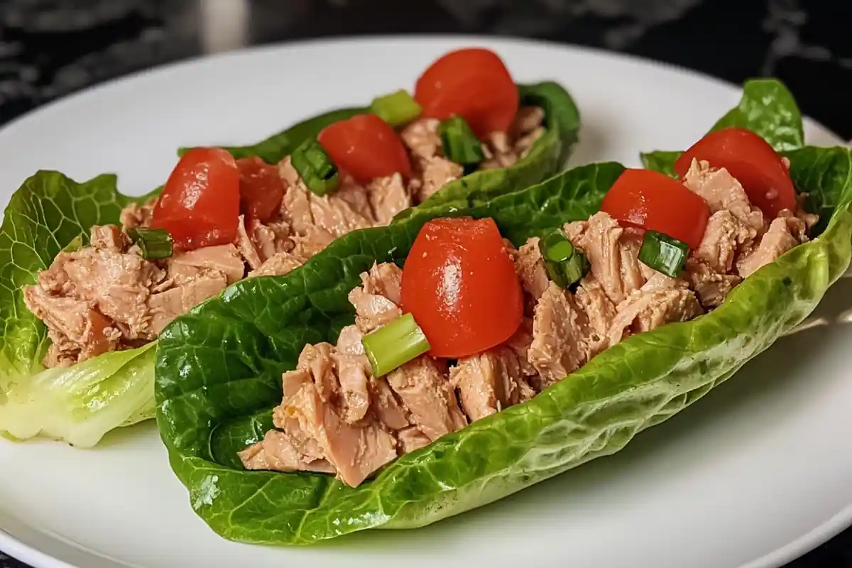 A tempting display of tuna lettuce wraps on a smooth marble surface.