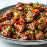 Tasty black pepper beef with all of its ingredients beautifully displayed on a marble top.